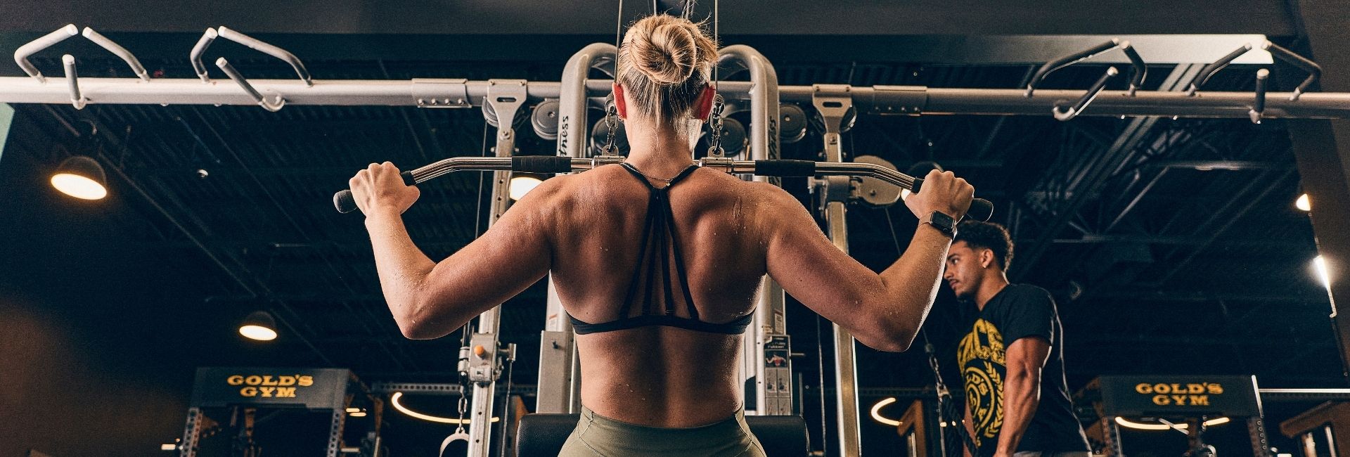 Back view of a lifter performing a lat pulldown on premium strength equipment at Gold’s Gym Arvada, a modern Mecca for serious bodybuilding and training.