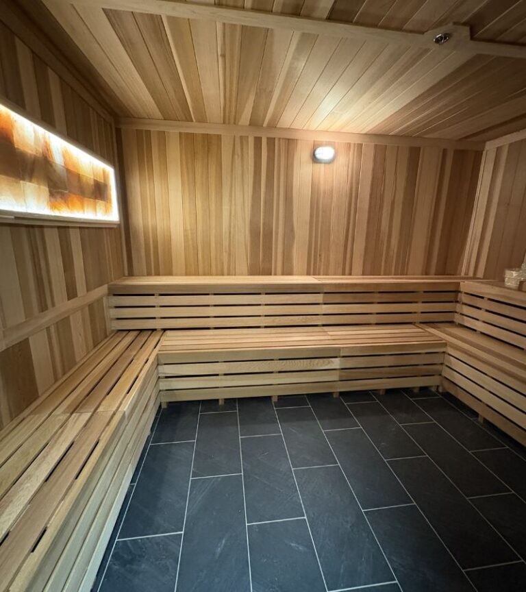 Dry sauna at Gold’s Gym Thornton with wood benches and warm lighting, offering a recovery amenity for members after serious training sessions.