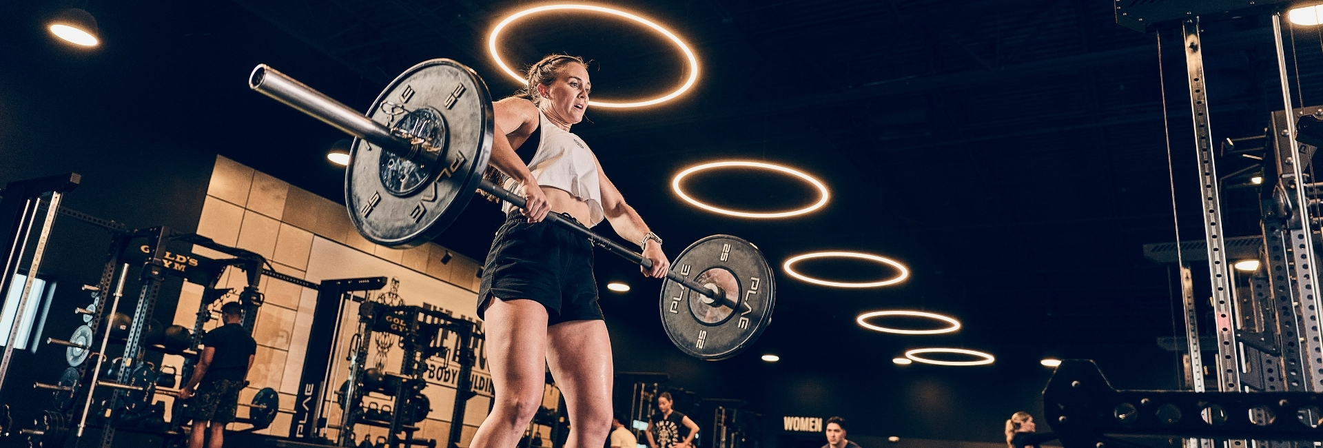 Member performing barbell lifts on the strength training platform at Gold’s Gym Thornton.