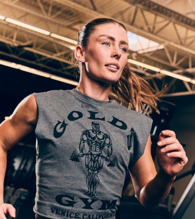 Woman running on a treadmill wearing a Gold's Gym shirt at a Gold's Gym fitness center in Colorado.